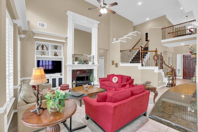 6628 Gray Wolf Dr, Plano, TX 75024 - living room featuring a towering ceiling, stairs, a fireplace, ceiling fan, and baseboards