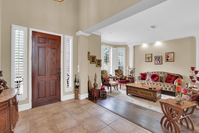 6628 Gray Wolf Dr, Plano, TX 75024 - foyer featuring light tile patterned floors, ornate columns, ornamental molding, and baseboards