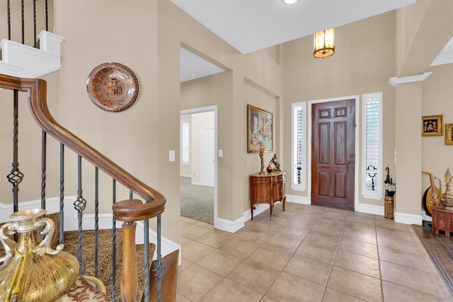6628 Gray Wolf Dr, Plano, TX 75024 - entryway with light tile patterned flooring, stairway, a high ceiling, and baseboards