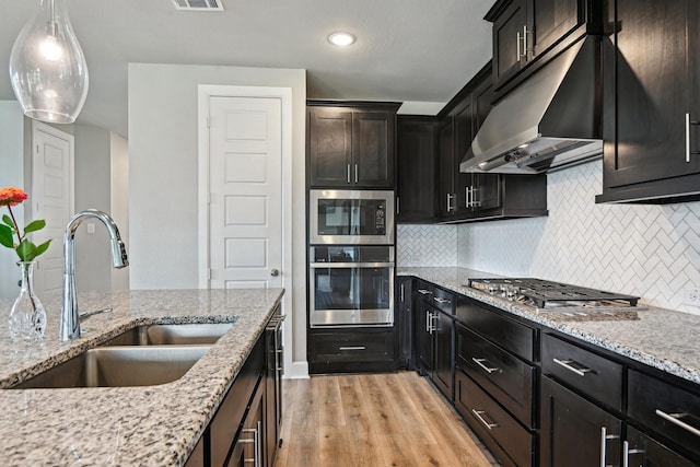 3200 Julian St, Mansfield, TX 76063 - kitchen featuring stainless steel appliances, a sink, under cabinet range hood, light wood-style flooring, and backsplash