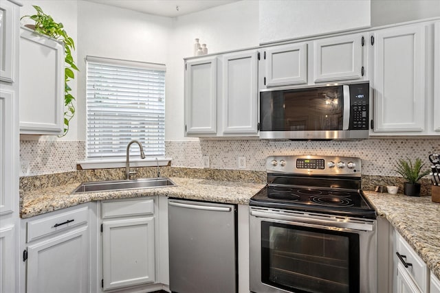 4116 Cole Ave Unit 302, Dallas, TX 75204 - kitchen featuring appliances with stainless steel finishes, a sink, decorative backsplash, and white cabinetry