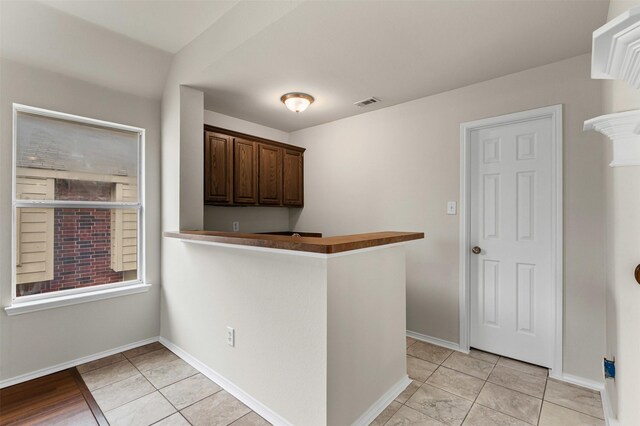 204 Forestview Rd, Hickory Creek, TX 75065 - kitchen with light tile patterned floors, dark brown cabinetry, and baseboards