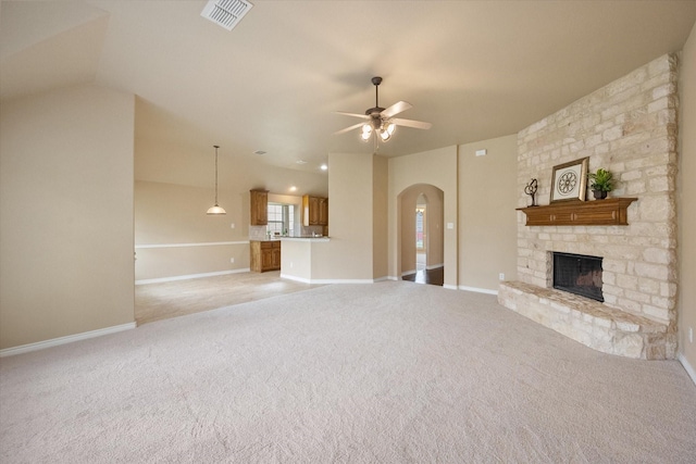 304 Adobe Lilly Ct, Mansfield, TX 76063 - unfurnished living room with arched walkways, ceiling fan, a stone fireplace, light colored carpet, and vaulted ceiling