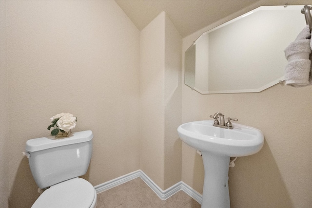304 Adobe Lilly Ct, Mansfield, TX 76063 - bathroom featuring toilet, lofted ceiling, tile patterned flooring, baseboards, and a sink