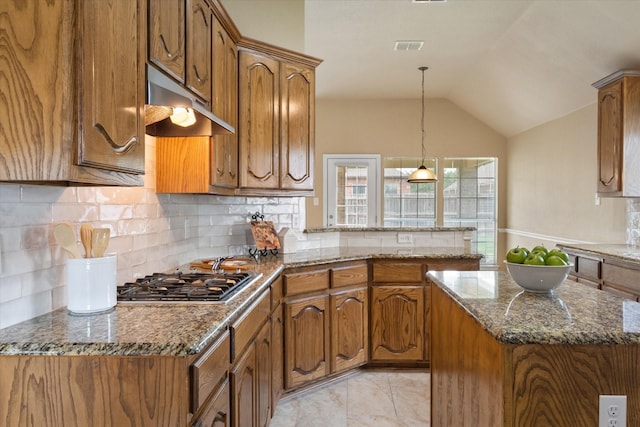 304 Adobe Lilly Ct, Mansfield, TX 76063 - kitchen with stainless steel gas stovetop, brown cabinetry, under cabinet range hood, a peninsula, and backsplash
