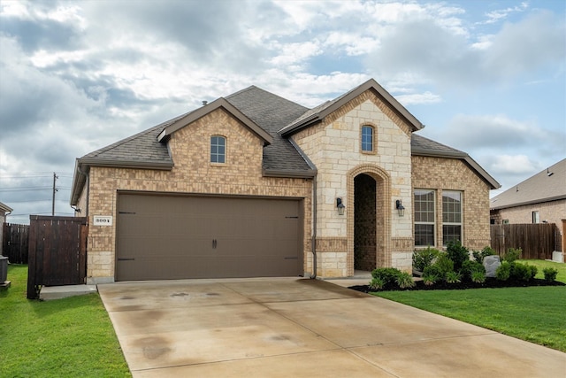 3004 Aransas Ave, Aubrey, TX 76227 - french country style house with a shingled roof, stone siding, and a garage
