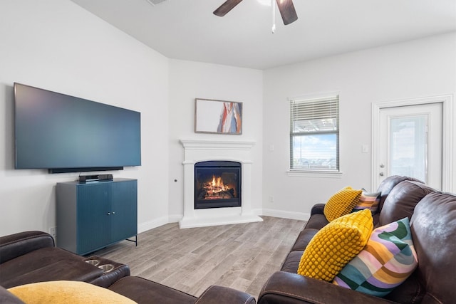3004 Aransas Ave, Aubrey, TX 76227 - living room featuring wood finished floors, a glass covered fireplace, ceiling fan, and baseboards