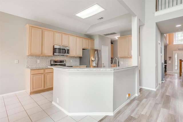 2604 Briarcrest Dr, Burleson, TX 76028 - kitchen featuring stainless steel appliances, light brown cabinetry, and decorative backsplash