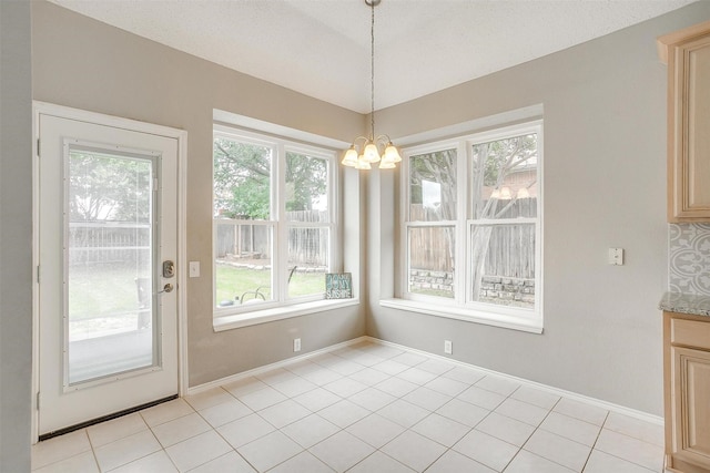 2604 Briarcrest Dr, Burleson, TX 76028 - unfurnished dining area with a chandelier, light tile patterned flooring, and baseboards