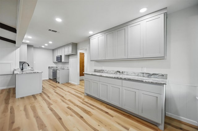 9813 Bancroft Dr, Benbrook, TX 76126 - kitchen with stainless steel appliances, a sink, light wood finished floors, light stone counters, and recessed lighting