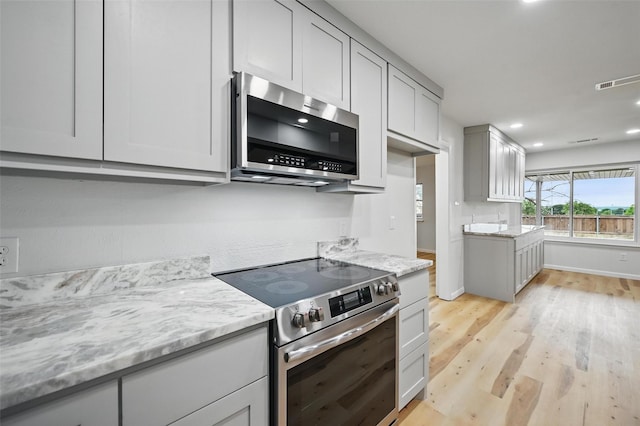 9813 Bancroft Dr, Benbrook, TX 76126 - kitchen with appliances with stainless steel finishes, light wood-style floors, light stone countertops, recessed lighting, and baseboards