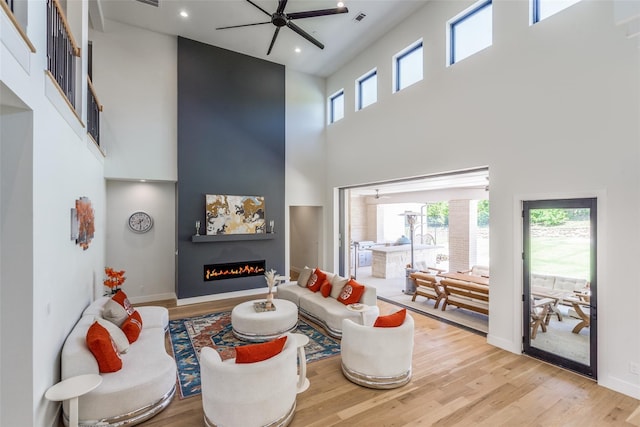 1209 Hicks Trl, Lucas, TX 75002 - living room featuring a high ceiling, ceiling fan, wood finished floors, a large fireplace, and recessed lighting