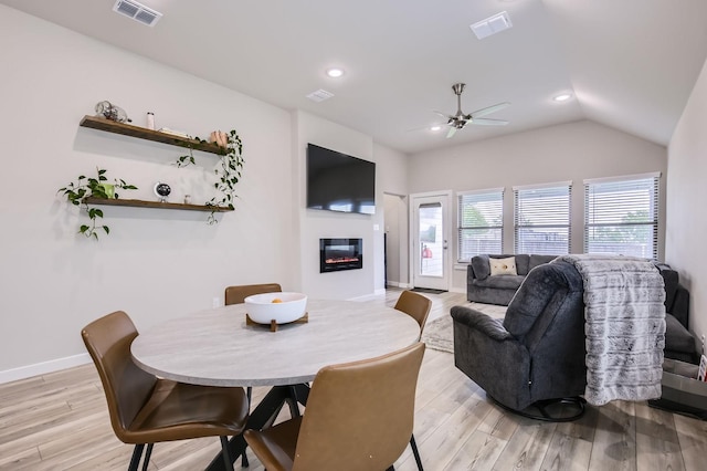 1211 Caddo Hill Ct, Royse City, TX 75189 - dining space with a ceiling fan, a glass covered fireplace, light wood-type flooring, lofted ceiling, and baseboards