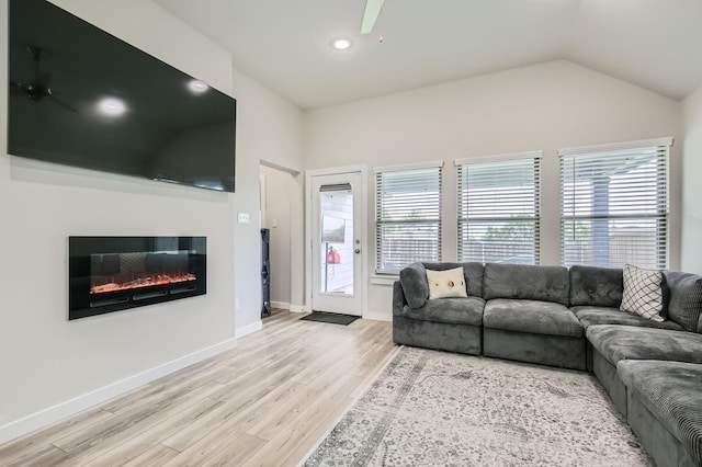 1211 Caddo Hill Ct, Royse City, TX 75189 - living area featuring a glass covered fireplace, wood finished floors, plenty of natural light, baseboards, and lofted ceiling