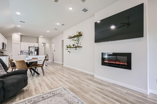 1211 Caddo Hill Ct, Royse City, TX 75189 - living area with ceiling fan, light wood-style floors, baseboards, a glass covered fireplace, and recessed lighting