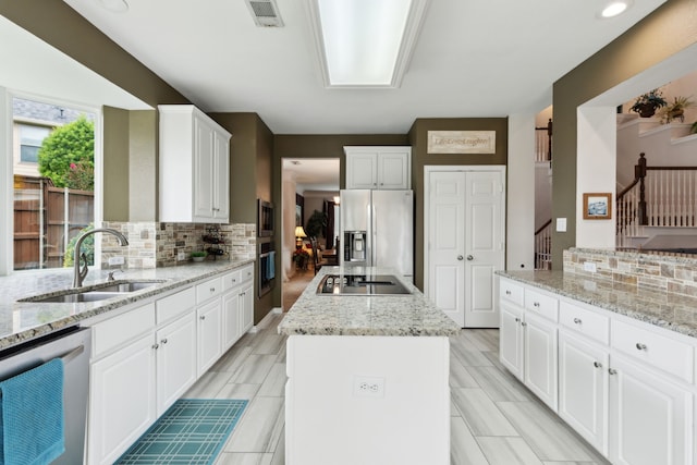6308 Widgeon Dr, Plano, TX 75024 - kitchen featuring appliances with stainless steel finishes, a sink, a center island, and decorative backsplash