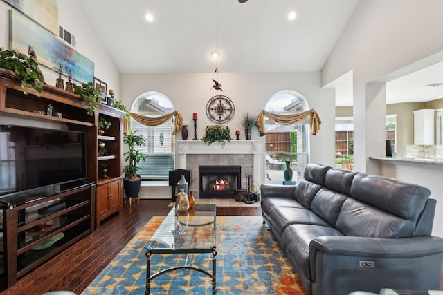 6308 Widgeon Dr, Plano, TX 75024 - living area with vaulted ceiling, dark wood-style flooring, a tiled fireplace, healthy amount of natural light, and recessed lighting