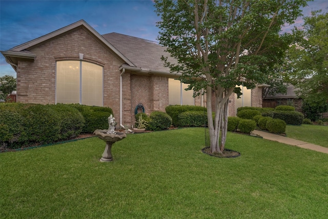 7717 Straits Dr, Rowlett, TX 75088 - view of front of home with brick siding, a lawn, and a shingled roof