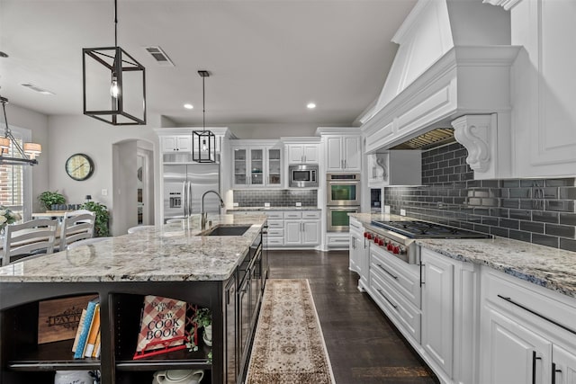 8249 Treemont Pl, Frisco, TX 75034 - kitchen featuring a sink, open shelves, built in appliances, white cabinets, and tasteful backsplash