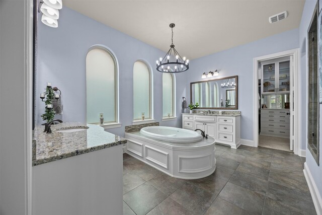 8249 Treemont Pl, Frisco, TX 75034 - full bathroom with two vanities, a garden tub, a chandelier, a shower, and baseboards