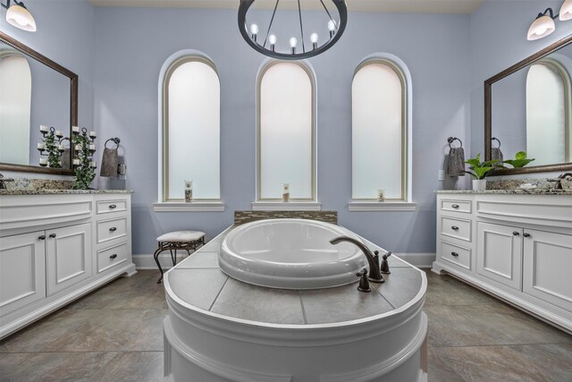 8249 Treemont Pl, Frisco, TX 75034 - bathroom featuring two vanities, a bath, healthy amount of natural light, and baseboards