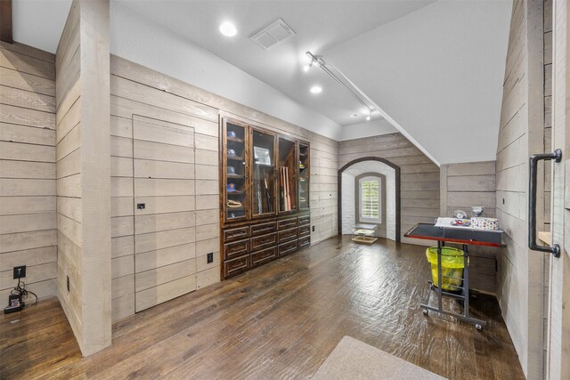 8249 Treemont Pl, Frisco, TX 75034 - living area featuring hardwood / wood-style flooring, wooden walls, arched walkways, recessed lighting, and vaulted ceiling