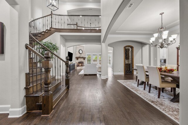 8249 Treemont Pl, Frisco, TX 75034 - foyer entrance with arched walkways, stairway, a chandelier, wood finished floors, and ornamental molding