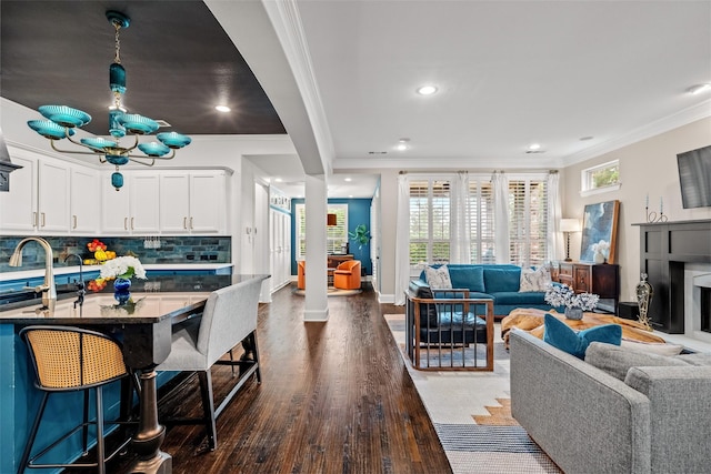 7905 Strathmill Dr, The Colony, TX 75056 - living room featuring crown molding, a chandelier, dark wood-style floors, recessed lighting, and baseboards