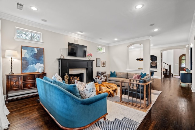 7905 Strathmill Dr, The Colony, TX 75056 - living area featuring arched walkways, a fireplace, wood finished floors, stairway, and recessed lighting