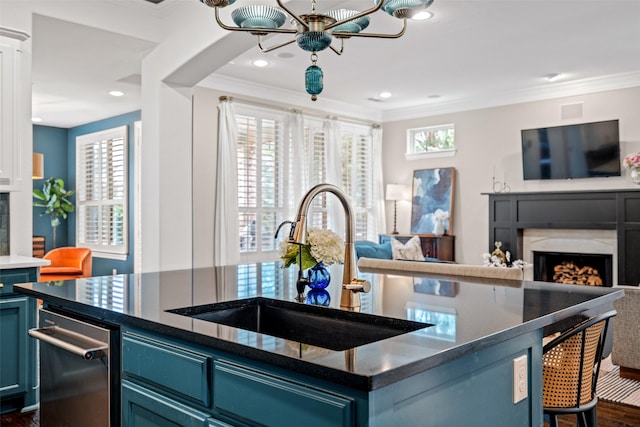 7905 Strathmill Dr, The Colony, TX 75056 - kitchen featuring a premium fireplace, blue cabinets, a sink, open floor plan, and crown molding