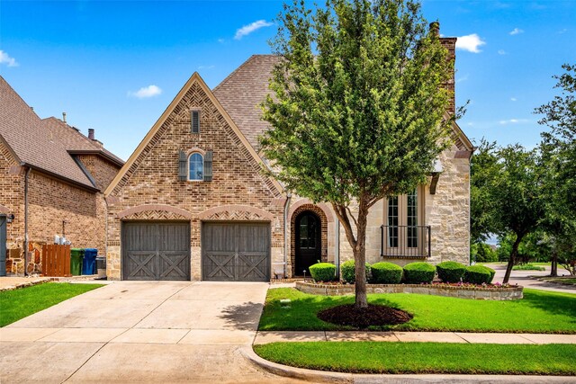 7905 Strathmill Dr, The Colony, TX 75056 - view of front of property with concrete driveway, brick siding, an attached garage, a front yard, and stone siding