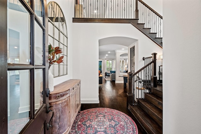 7905 Strathmill Dr, The Colony, TX 75056 - entrance foyer with arched walkways, wood finished floors, stairway, a high ceiling, and baseboards