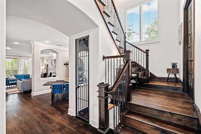 7905 Strathmill Dr, The Colony, TX 75056 - stairs featuring wood finished floors, arched walkways, baseboards, recessed lighting, and ornamental molding