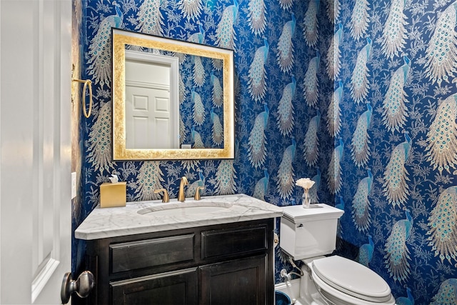 7905 Strathmill Dr, The Colony, TX 75056 - half bathroom featuring wallpapered walls, toilet, and vanity