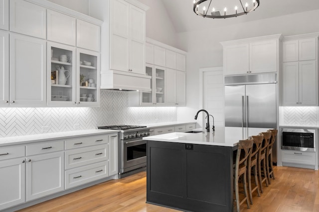 1619 Sterling Ct, Celina, TX 75009 - kitchen with built in appliances, a sink, custom range hood, decorative backsplash, and a chandelier