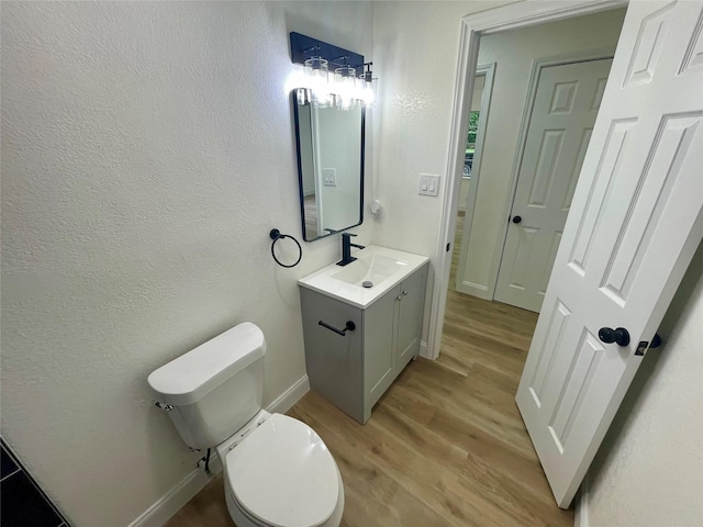 126 Stephens St, Waxahachie, TX 75165 - bathroom with wood finished floors, vanity, toilet, and baseboards