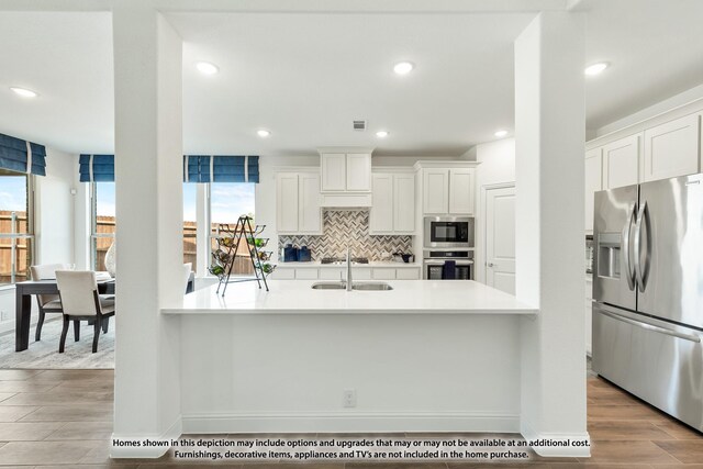 3418 Abingdon Dr, Melissa, TX 75454 - kitchen featuring stainless steel appliances, light countertops, white cabinetry, tasteful backsplash, and wood finished floors