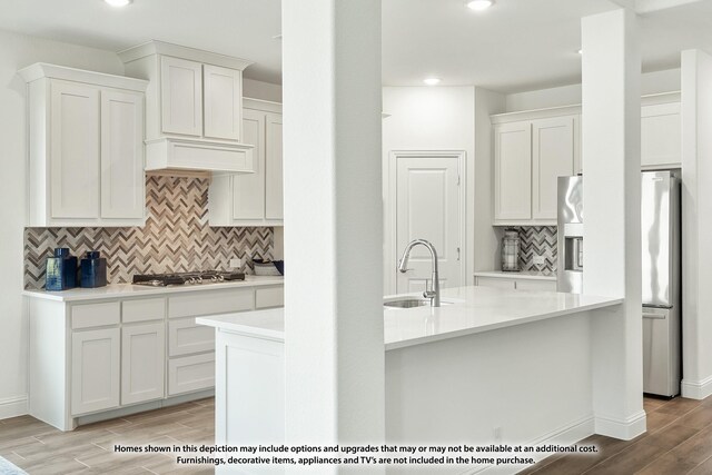 3418 Abingdon Dr, Melissa, TX 75454 - kitchen with stainless steel appliances, a sink, light wood finished floors, light countertops, and tasteful backsplash