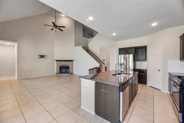 1503 E Collins Blvd, Wylie, TX 75098 - kitchen featuring appliances with stainless steel finishes, a sink, light tile patterned floors, dark stone countertops, and ceiling fan