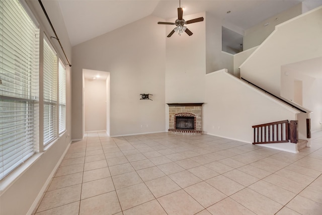 1503 E Collins Blvd, Wylie, TX 75098 - unfurnished living room featuring high vaulted ceiling, ceiling fan, light tile patterned flooring, a brick fireplace, and baseboards