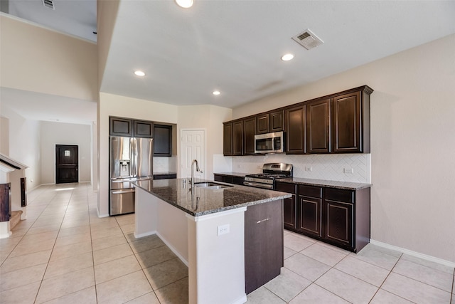 1503 E Collins Blvd, Wylie, TX 75098 - kitchen with appliances with stainless steel finishes, a sink, light tile patterned flooring, dark stone countertops, and decorative backsplash