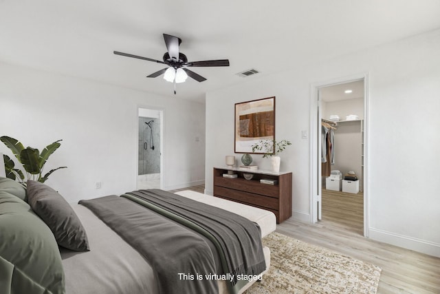 783 Eiffel Dr, Plano, TX 75023 - bedroom with light wood finished floors, a walk in closet, baseboards, connected bathroom, and a ceiling fan