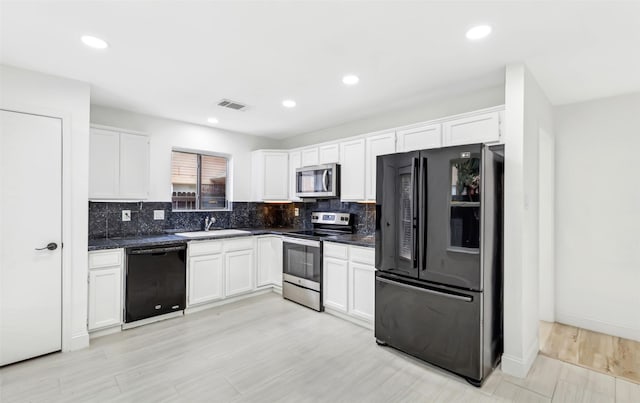 783 Eiffel Dr, Plano, TX 75023 - kitchen featuring black appliances, a sink, dark countertops, white cabinets, and recessed lighting
