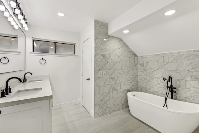 783 Eiffel Dr, Plano, TX 75023 - bathroom featuring a freestanding tub, double vanity, tile walls, and recessed lighting
