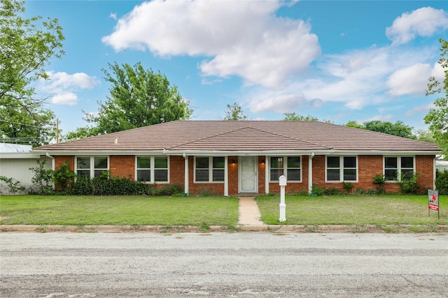 201 Palestine St, Coleman, TX 76834 - ranch-style home featuring a front yard, a tile roof, and brick siding
