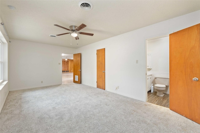 201 Palestine St, Coleman, TX 76834 - unfurnished bedroom featuring carpet, ensuite bathroom, a ceiling fan, and baseboards