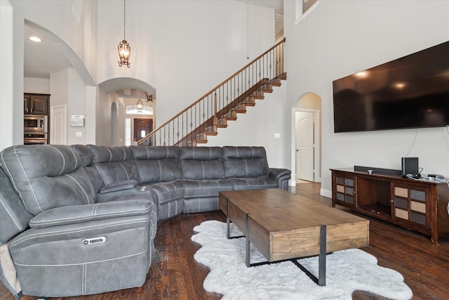 3302 Blue Jay Ln, Melissa, TX 75454 - living room featuring arched walkways, a towering ceiling, wood finished floors, and stairway