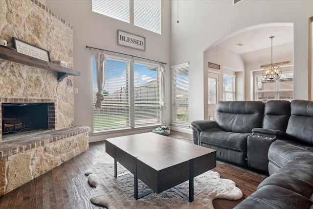 3302 Blue Jay Ln, Melissa, TX 75454 - living room featuring wood-type flooring, arched walkways, a chandelier, plenty of natural light, and a towering ceiling