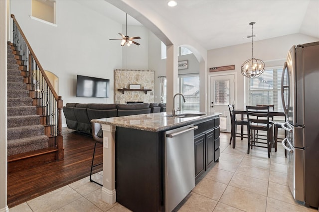 3302 Blue Jay Ln, Melissa, TX 75454 - kitchen with appliances with stainless steel finishes, a sink, ceiling fan, light tile patterned floors, and arched walkways