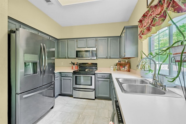 1908 Timberline Ln, Sherman, TX 75092 - kitchen featuring appliances with stainless steel finishes, a sink, gray cabinetry, and light countertops
